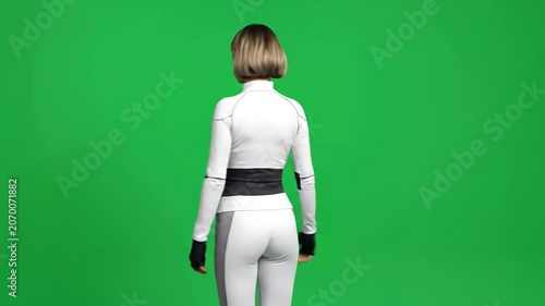 A young woman in athletic gear stands against green screen