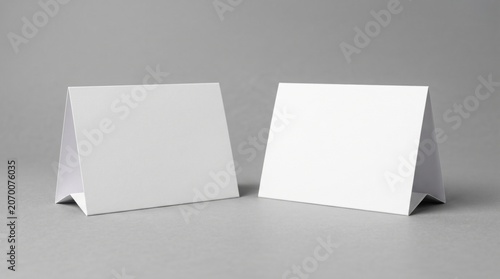 Blank table tent cards standing on gray surface with clean studio lighting for restaurant menu and event branding