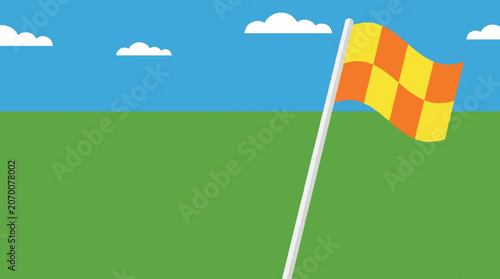 Yellow and Orange Checkered Sports Linesman Flag Waving on a Green Field Under a Clear Blue Sky