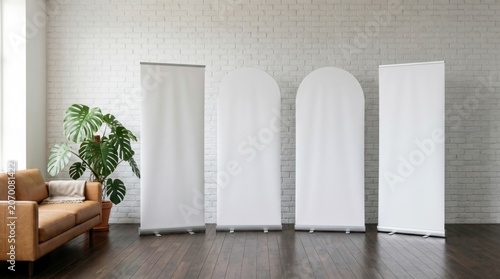 Roll up banner stands lined up in a bright loft with a white brick wall and monstera plant for corporate events and marketing presentations
