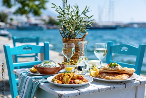 Greek seaside taverna table set for lunch overlooking picturesque port