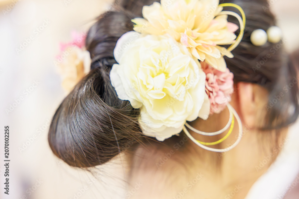 Naklejka premium 華やかな造花の髪飾りをあしらった着物姿の女性のヘアスタイル（後ろ姿）