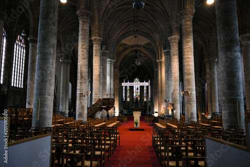 Foto Interior of a historic Gothic cathedral with a red carpet aisle, tall columns, wooden pews, and vaulted arched ceiling