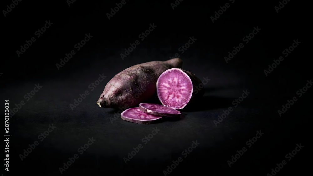 Obraz premium Sliced purple sweet potato on black surface – Ideal for exotic root vegetable promotions, vegan meal kits, or gourmet food photography.