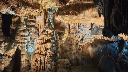 Foto Illuminated Limestone Cave Interior with Stalactites and Stalagmites