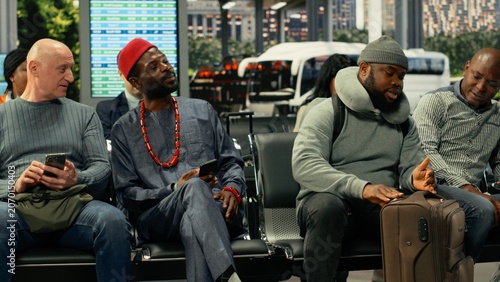 Konstfotografi Multiethnic group of travelers talking about route waiting in bus station, becoming friends while waiting for daily commute coach