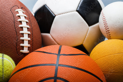 Close-Up of Sports Balls Including Football, Soccer Ball, Basketball, Baseball, Tennis Ball and Medicine Ball Arranged Together