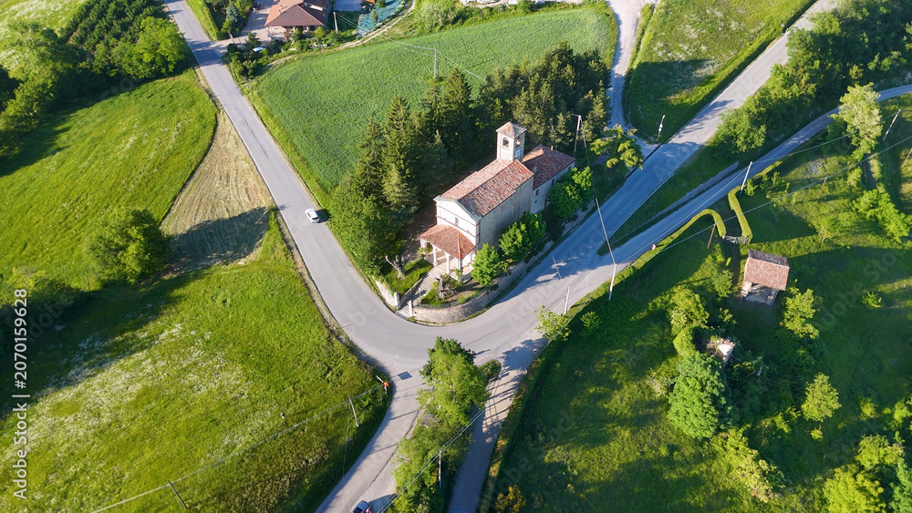 Fototapeta premium Aerial View of a Rural Church and Winding Roads in Piedmont
