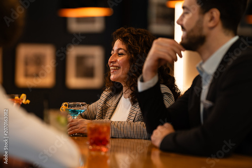 Konstfotografi Happy business people enjoying after work drinks at a bar