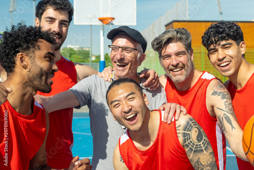Fotografi Diverse male basketball team laughing on outdoor court