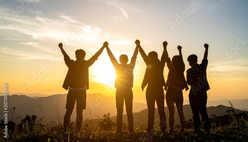 Silhouettes of friends celebrating on hilltop, sunset sky, unity concept