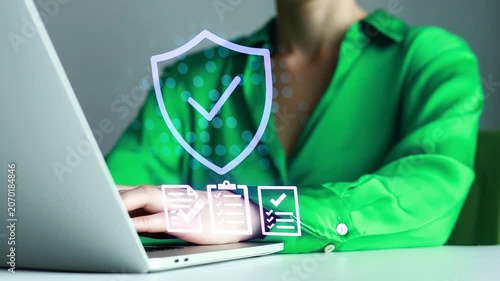 Person works on laptop with security symbols on screen in an office setting during the day.