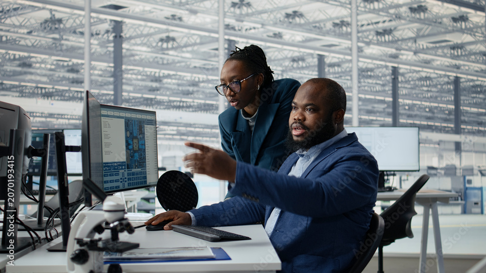 Naklejka premium Man and woman modeling integrated circuit systems with PC software in RD office, African american coworkers use computer to optimize microchip hardware manufacturing in tech laboratory, camera A.
