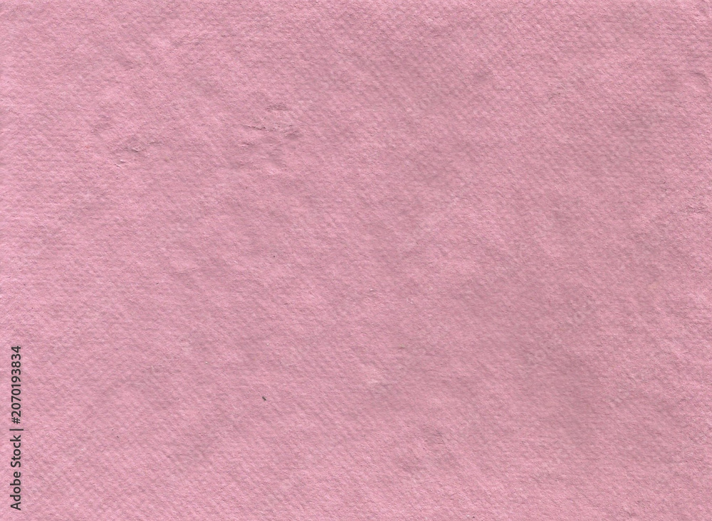 Fototapeta premium texture of thick handmade artisan paper in a soft dusty pink hue. The full-frame close-up captures a grainy surface with subtle fiber specks, dimples, and a vintage matte layout for elegant design wor
