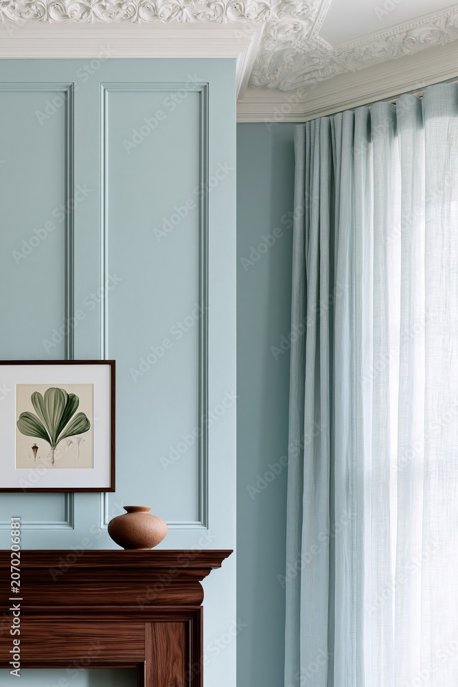 Fototapeta premium Living room corner featuring a dark walnut mantelpiece, light blue wall with decorative paneling, and a framed botanical print above a ceramic vase