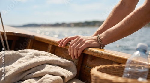 Young woman hands resting on wooden boat gunwale wearing rope bracelet on sunny day, nautical lifestyle concept for summer travel and leisure