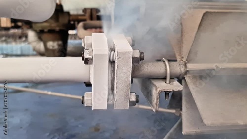 Sidoarjo, Indonesia - 26 June, 2026: Industrial Pipe Flange Leaking Steam: High Pressure Gas Escaping from Frosted Metal Joint