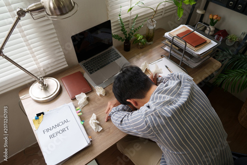 Cuadro en lienzo Exhausted Asian businessman sleeping on desk with financial report and laptop
