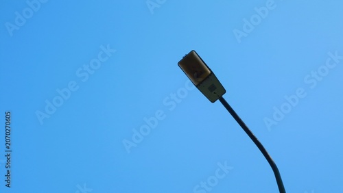 Close-up shot of a black electrical plug against a clear blue sky