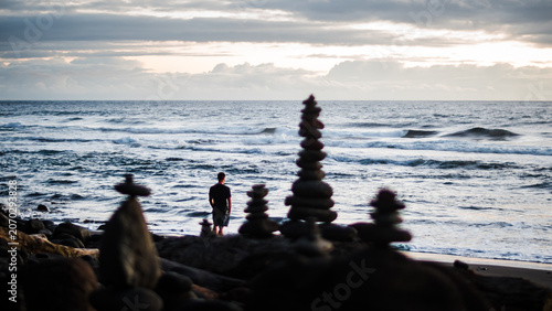  Man at Ocean Shore with Cairns
