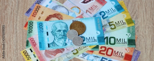 Costa Rican colon money bills and coins on table. Costa Rica cash of CRC currency close up