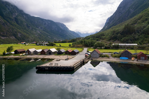Obraz na plátně Panoramic drone shot of a small village in a Norwegian fjord valley