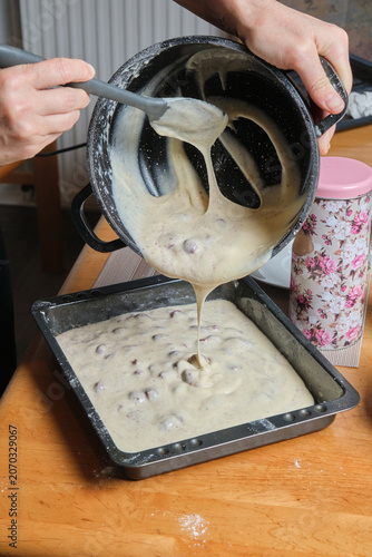 Spreading creamy batter smoothly into ovenready tray. Precisely filling and smoothing batter in tray for hot oven baking