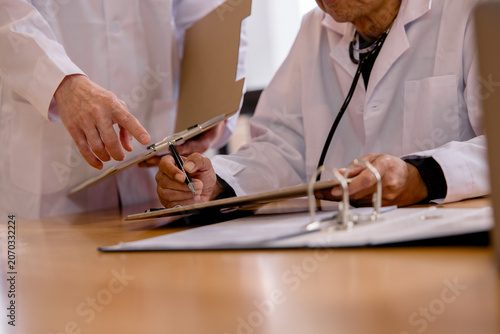 Fotografía Healthcare professionals reviewing patient records and discussing medical documentation in a clinical office