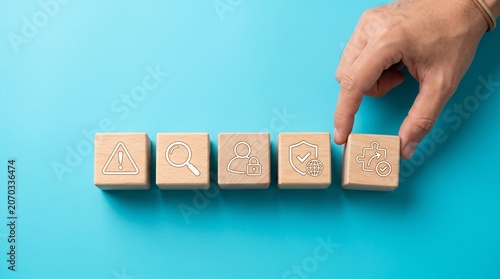 Hand placing wooden block with puzzle piece icon on blue background with security and warning symbols