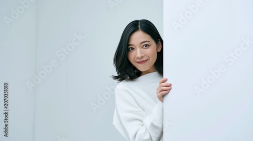 Woman smiling while holding a clean white vertical panel for branding and advertising use in a minimal white studio setting.