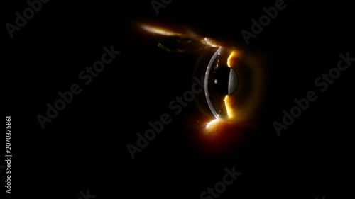 A human eye slowly comes into focus from deep darkness with warm golden highlights. The pupil dilates slightly as light catches the iris. Dramatic cinematic reveal with moody atmosphere intense gaze