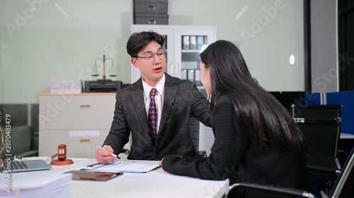 Asian attorney offering support and legal advice to a distressed woman during an office