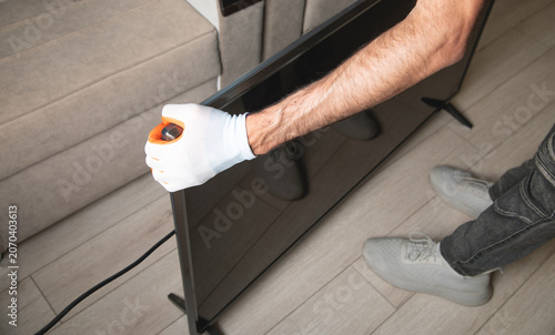 Man to move TV at other room.