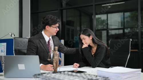 Asian attorney offering support and legal advice to a distressed woman during an office