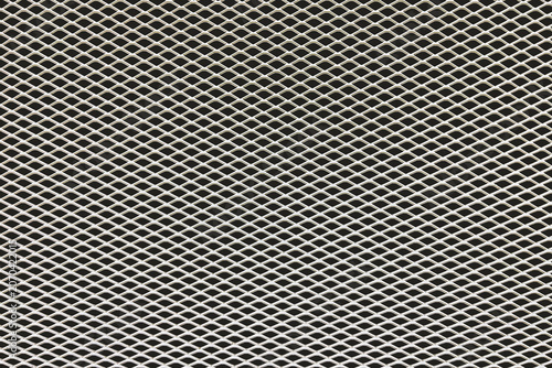 Close up of expanded metal mesh texture with geometric pattern. Industrial steel grid background for design, construction and technology concepts