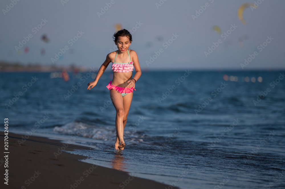 Fototapeta premium Girl running on beach enjoying summer vacation