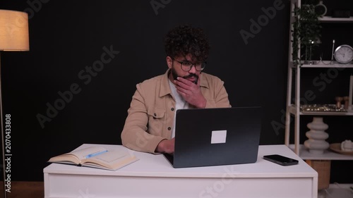 Stressed man experiencing headache working on laptop