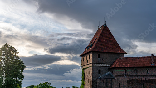 Historic medieval tower of Malbork Castle beneath dramatic storm clouds