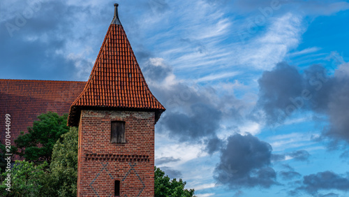 Medieval brick watchtower of Malbork Castle against dramatic cloudy sky