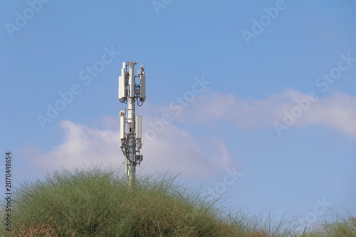 Telecommunication tower on the top of dunes with blue sky background