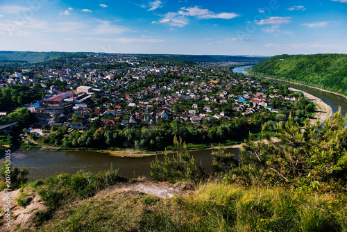 Elevated view of Zalishchyky and the winding Dniester River, showcasing green valleys, residential neighborhoods, and scenic natural surroundings.