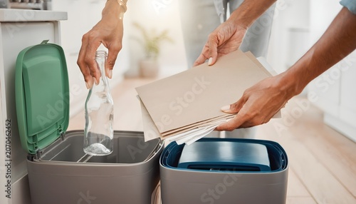 People hands sorting glass bottle and cardboard paper into different recycling bins