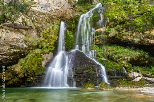 Long exposure of beautiful cascading Virje Waterfall in green nature, Slovenia, Europe