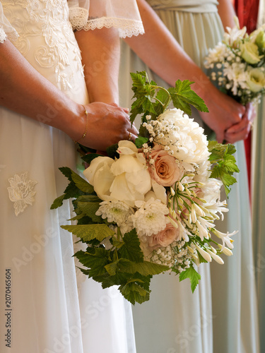 Foto Mariée tenant un bouquet de fleurs blanches et roses lors d’un mariage