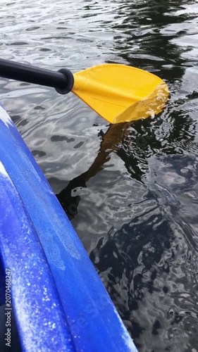 Close-up of a yellow paddle for a blue kayak.
