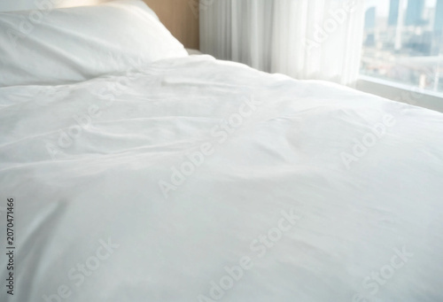 Empty bed with fresh white linens and pillow in bright modern hotel room with city view apartment interior comfortable relaxation minimalist