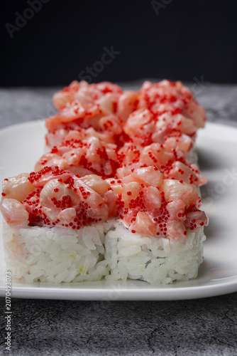 Sushi roll with crab meat and caviar on a plate.