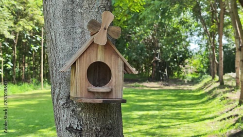 A wooden birdhouse on a tree.