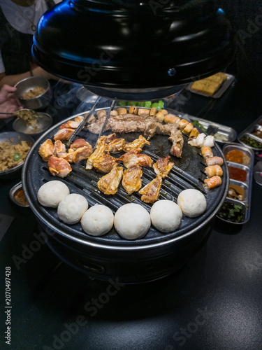 Grilled Seafood and Meat on Korean BBQ Grill with Side Dishes