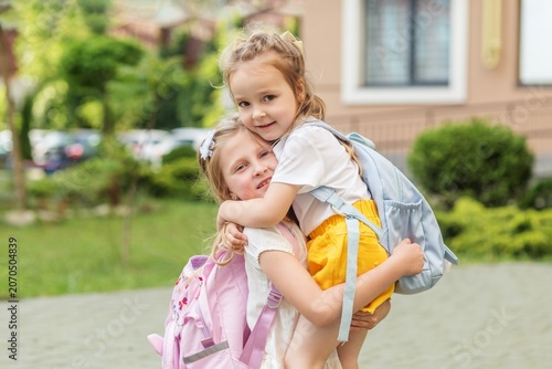 Two sisters hugging before going to school and preschool
